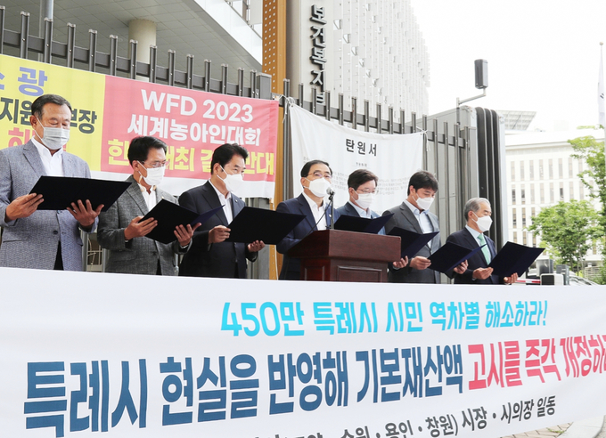 4개 특례시 시장과 시의회 의장들이 보건복지부 청사 앞에서 피켓을 들고 사회복지급여 기본재산액 기준개선을 촉구하고 있다. (사진=용인시 제공)