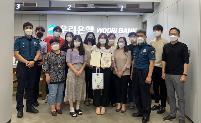인천남동경찰서 구월지구대 경찰관과 우리은행 구월지점 직원들이 함께 사진촬영을 하고 있다. ( 사진 = 남동경찰서 제공 )