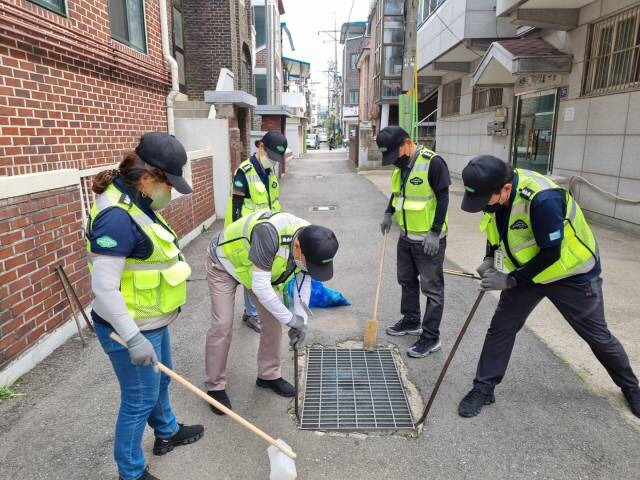 군포시 산본1동 경기행복마을관리소 지킴이들이 빗물받이 청소 및 소독작업을 하고 있다. (사진=군포시 산본1동 제공)