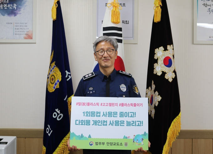 최제영 안양교도소장이 "1회용컵 사용은 줄이고! 다회용 개인컵 사용은 늘리고!"라는 문구가 적힌 팻말을 들고 ‘고고 챌린지’를 동참하고 있다. (사진=안양교도소 제공)