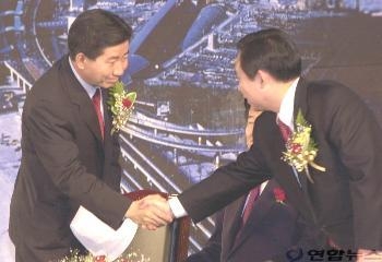 인천전문대체육관에서 열린 민주당 인천경선대회에서 연설을 마친 노무현후보와 이인제후보가 악수를 하고 있다. (사진 = 연합뉴스 제공)