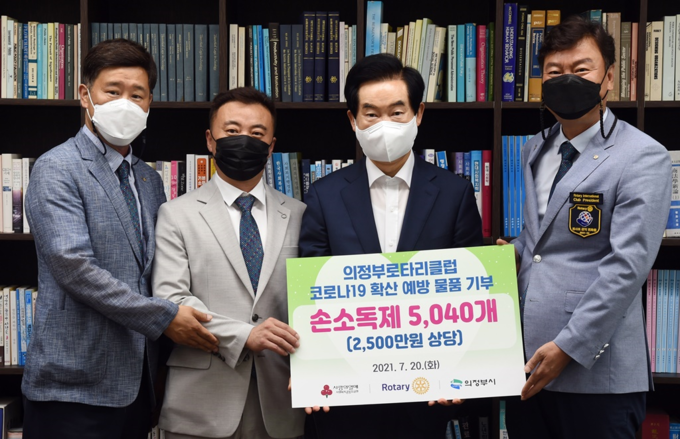 의정부로타리클럽 박돈신 회장(사진 왼쪽 두번째)과 회원들이 코로나19 확산 예방을 위해 손소독제 5000여 개(2500만 원 상당)를 의정부시에 기탁하고 안병용 의정부시장(오른쪽 두번째))과 기념촬영을 하고 있다.. (사진=의정부로타리클럽 제공)