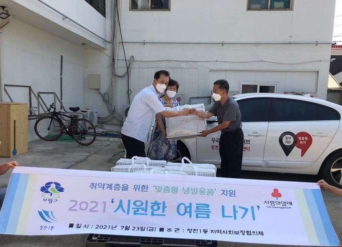 청천1동 지역사회보장협의체 김성권 위원장이 주민에게 여름이불을 전달하고 있다. ( 사진 = 부평구 제공 )