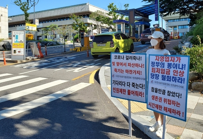 26일 오전 인천시청과 인천시의회 앞에서 A(22)씨가 사회적 거리두기 4단계에 따른 영업제한 해제를 요구하는 릴레이 1인시위를 진행하고 있다. A씨는 인천 중구 월미도에서 커피숍을 운영하고 있다. ( 사진 = 최태용 기자 )