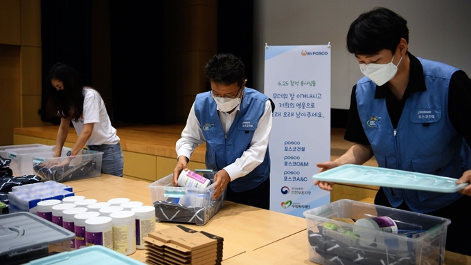 포스코건설 사내봉사단 임직원들이 6.25참전유공자 가정에 전달할 폭염 키트를 제작하고 있다. ( 사진 = 포스코건설 제공 )