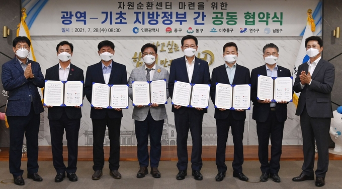 28일 시청 대접견실에서 열린 '자원순환센터 마련을 위한 광역-기초 지방정부 간 공동협약식'에서 박남춘 시장 등 참석자들이 협약서를 들어보이고 있다. 왼쪽부터 오흥석 시 교통환경조정관, 이강호 남동구청장, 고남석 연수구청장, 김정식 미추홀구청장, 박남춘 시장, 허인환 동구청장, 홍인성 중구청장, 조택상 균형발전정무부시장. ( 사진 = 인천시 제공 )
