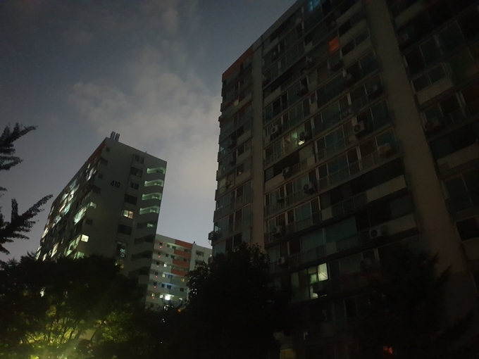 정전으로 불이 꺼진 만수주공 4단지(오른쪽)와 전력 공급이 정상적으로 이뤄지고 있는 5단지의 모습이 대조적이다. ( 사진 = 최태용 기자 )