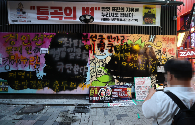 서울 종로구 관철동의 한 중고서점 앞에 윤석열 전 검찰총장 아내 김건희 씨를 비방하는 내용의 벽화가 게시돼 논란이 이어지는 가운데 한 유튜버가 벽화 위에 검은색 페인트로 덧칠했다. 사진은 31일 검은색 페인트로 덧칠된 벽화. (사진=연합뉴스)