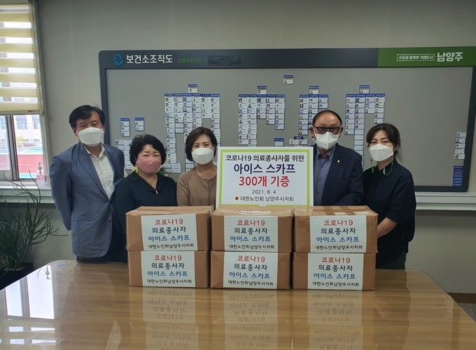 대한노인회남양주시지회가 폭염 속에서 힘들게 근무하는 코로나 선별진료소 직원들을 위해 4일 남양주보건소 남미숙 소장을 만나 쿨 스카프 300개를 전달했다. (사진=남양주시 제공)