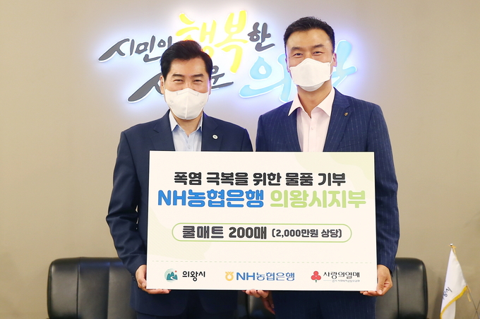 김상돈 의왕시장(사진 왼쪽)이 한명호 NH농협은행 의왕시지부장과 함께 '폭염 극복을 위한 쿨매트 200매 물품 기부 팻말을 들고 기념촬영을 하고 있다. (사진=NH농협은행 의왕시지부 제공)