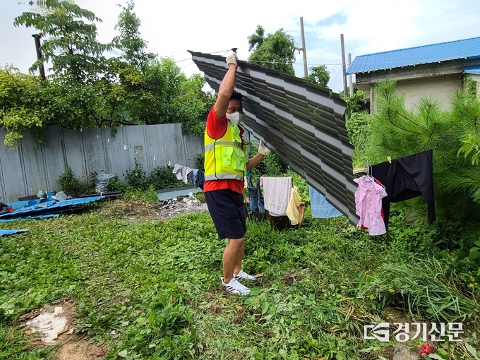 지붕고치기에 나선 내촌면자율방범대원이 새 지붕 판넬을 옮기고 있다. (사진=포천시자원봉사센터 제공)