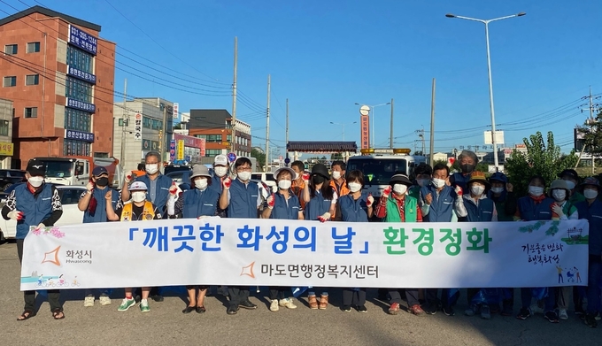 화성시 마도면행정복지센터는 9일 오전 마도면 농산물직거래장터 일대에서 '깨끗한 화성의 날' 환경정화 캠페인을 펼쳤다. (사진=화성 마도면행정복지센터 제공)
