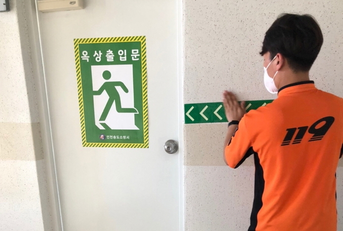  송도소방서 대원이 안전 픽토그램 을 부착하고 있다. ( 사진 = 송도소방서 제공 )