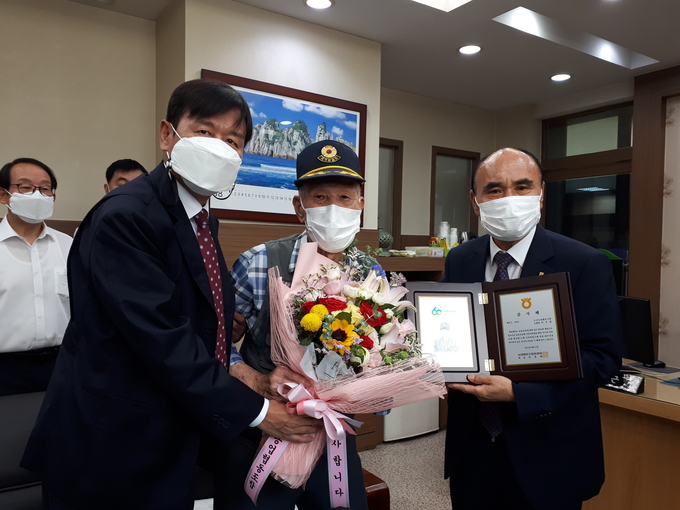 이기택 오산농협 조합장(사진 오른쪽)과 김병배 NH농협 오산시지부장이 지역 최고령 조합원인 이모씨에게 감사패를 건네고 기념촬영을 하고 있다. (사진= NH농협 오산시지부 제공)