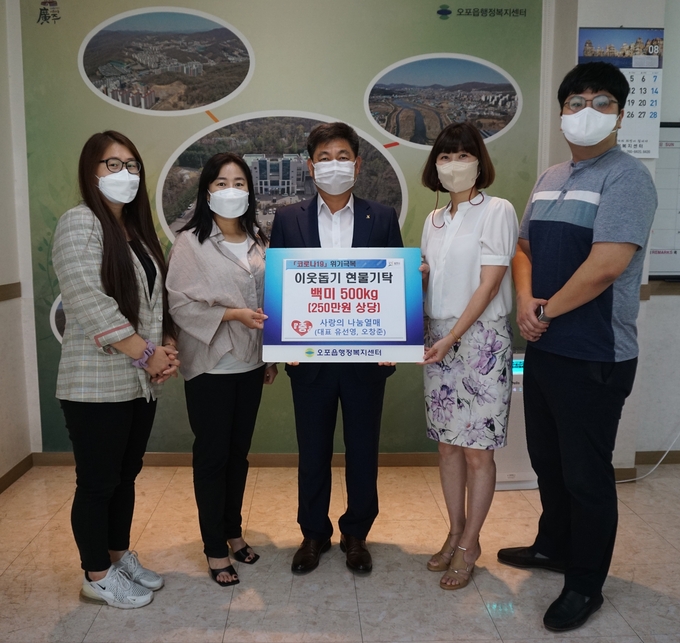 사랑의나눔 열매회원들이 광주시 권용석 오포읍장에게 취약계층에 써달라며 현물을 기탁하고 있다. (사진=광주시 제공)