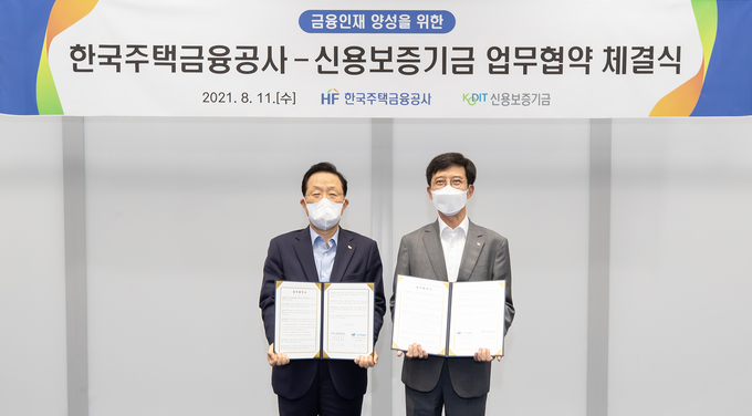 11일 경북 경주시 한국주택금융공사 미래인재원서 열린 ‘금융인재 양성을 위한 업무협약식’에서 윤대희 신용보증기금 이사장(왼쪽)과 최준우 한국주택금융공사 사장(오른쪽)이 MOU 체결 후 기념촬영을 한 모습. (사진=신용보증기금 제공)