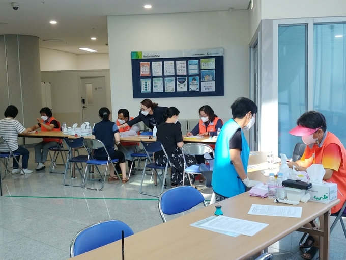 광주시통합자원봉사지원단이 무더위 속에도 코로나19 백신예방접종센터를 지원하고 있다. (사진=광주시 제공)
