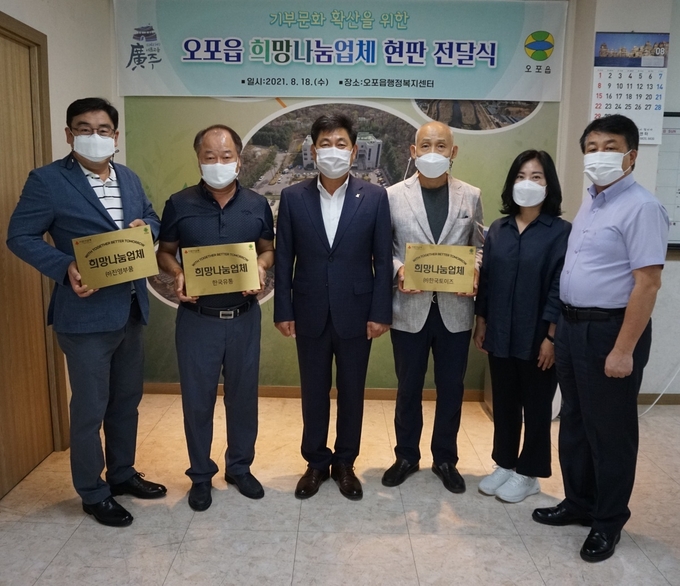 광주시 오포읍이 지역 기업체들의 기부에 대해 고마움으로 준비한 희망나눔업체 현판을 만들어 전달하고 있다. (사진=광주시 제공)