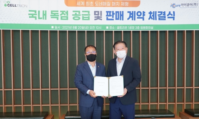  도네페질 패치 공급 및 판매 계약 체결서에 서명한 뒤 셀트리온과 아이큐어 양 사 대표가 함께 사진촬영을 하고 있다. ( 사진 = 셀트리온 제공 )