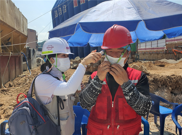 상시 대기 중인 보건 관리자가 현장에 투입된 인부의 발열 여부를 체크하는 모습 (사진=용인8구역 재개발 현장)
