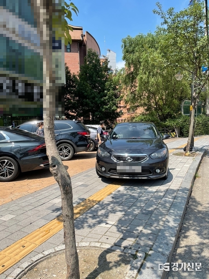 수원시 영통구 일대 인도 위에 불법 주·정차된 차량들로 인해 시민들이 통행에 불편을 겪고 있다. (사진=김기현 기자)