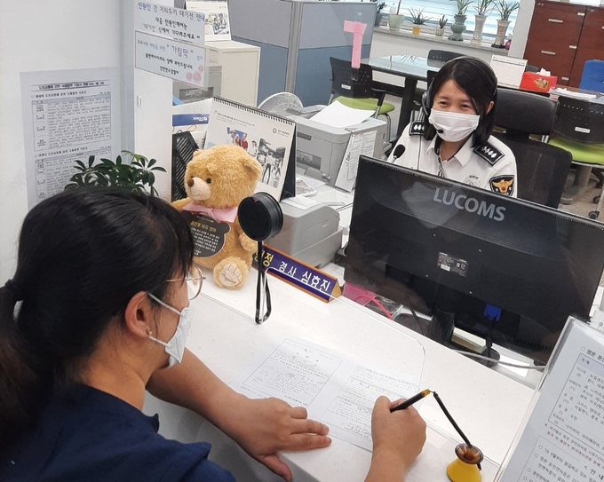 연수경찰서 민원실 직원이 양방향 마이크를 통해 민원인과 이야기를 나누고 있다. ( 사진 = 연수서 제공 )