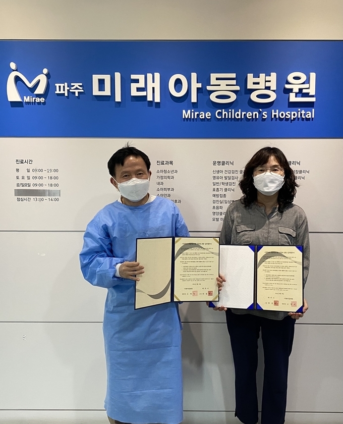파주시와 미래아동병원이 아동학대전담의료기관 지정 협약을 갖고 협약서를 들어보이고 있다. (사진=파주시 제공)