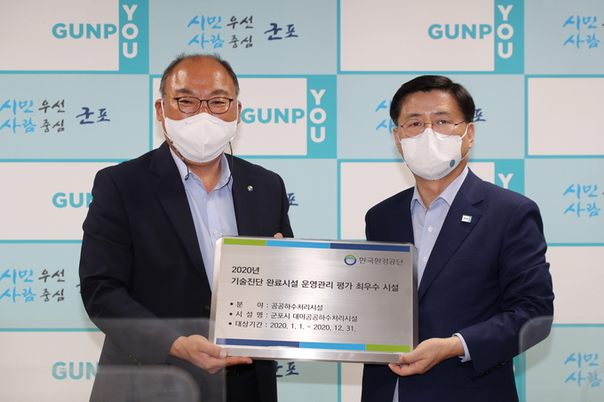 한대희 군포시장(사진 오른쪽)이 정태환 한국환경공단 환경시설본부장으로부터 공단 공공환경시설 평가 최우수시설 증패를 건네받고 있다. (사진=군포시 제공)