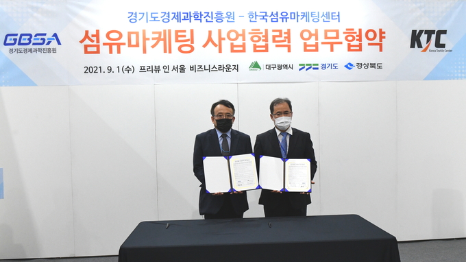 1일 프리뷰인서울 전시장 비즈니스라운지에서 열린 경기도경제과학진흥원과 한국섬유마케팅센터 간 ‘국내 섬유산업 발전을 위한 업무협약식’에서 (왼쪽부터) 유승경 경과원 원장과 한국섬유마케팅센터 강영광 이사장이 협약서를 들고 기념촬영하고 있다. (사진= 경과원 제공)