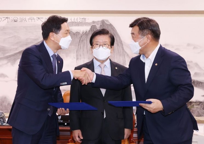 윤호중 더불어민주당 원내대표(오른쪽)와 김기현 국민의힘 원내대표가 지난달 31일 서울 여의도 국회 의장실에서 언론중재법 개정안을 위한 협의체 구성, 이번 달 27일 본회의 상정 등의 합의문을 교환하고 있다. 가운데는 박병석 국회의장. (사진=연합뉴스 ) 