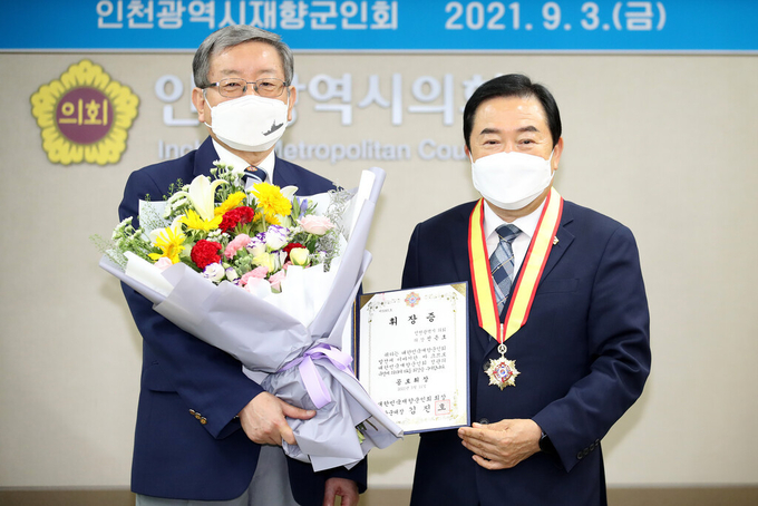 신은호 인천시의장(오른쪽)이 김형년 인천시재향군인회장으로부터 향군공로휘장을 전수받고 있다. ( 사진 = 인천시의회 제공 )