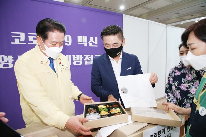 김일환 한송정 대표가 정성껏 준비한 도시락 66개를 접종센터에 전달하고 있다. (사진=안양시 제공)