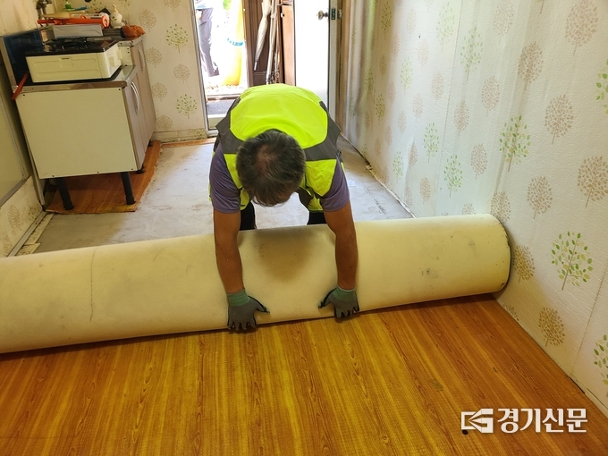영중면주민자치위원회 한 위원이 새 장판을 깔고 있다. (사진=포천시종합자원봉사센터 제공)