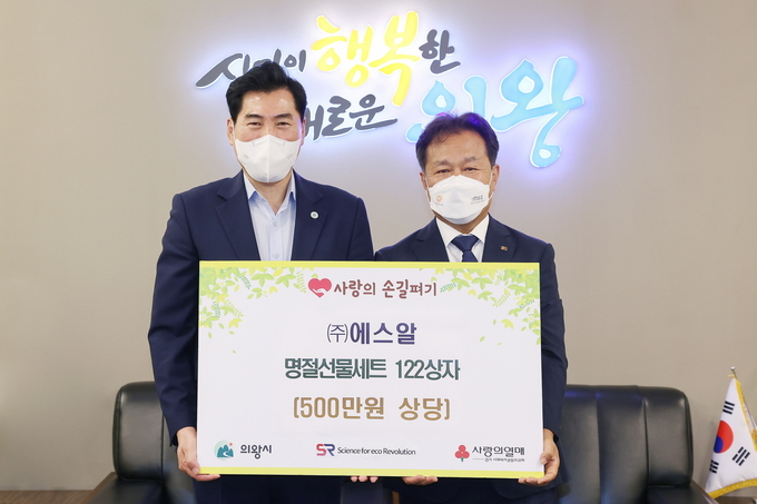 김상돈 의왕시장(사진 왼쪽)이 강춘기 에스알 대표로부터 명절선물세트 122상자(500만 원 상당)를 전달받고 있다. (사진=의왕시 제공)