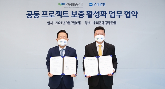 윤대희 신용보증기금 이사장(사진 왼쪽)과 권광석 우리은행 은행장(오른쪽)이 7일 서울 중구 우리은행 본점에서 열린 ‘공동 프로젝트 보증 활성화 업무협약식’에 참석해 기념촬영을 한 모습. (사진=신용보증기금 제공)