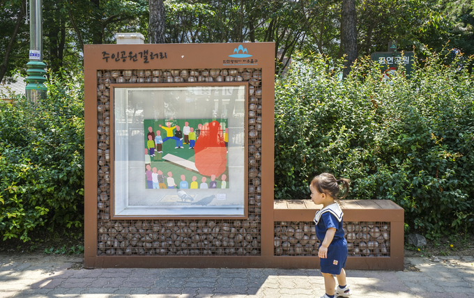 주인공원에 설치된 갤러리 앞은 동네 꼬마가 지나가고 있다. 