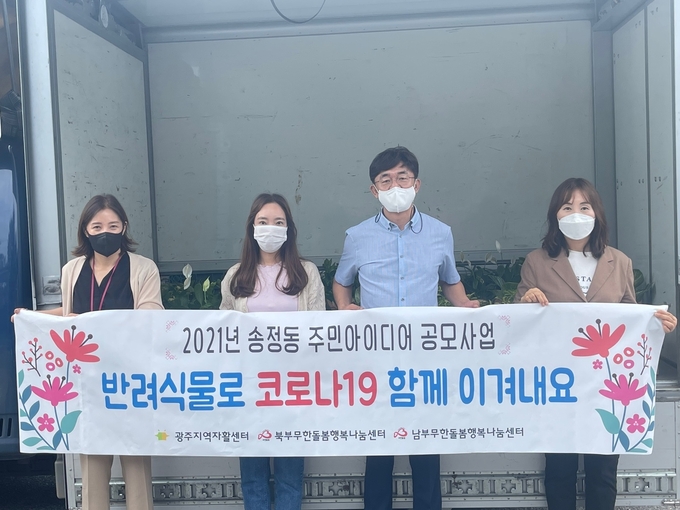 광주지역자활센터관계자들이 100개의 반려식물을 무한돌봄행복나눔센터에 기탁하고 있다.(사진=광주시 제공)
