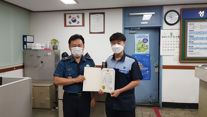성남 중원경찰서 정재남 서장을 대신해 성호지구대 박상국 지구대장이 보이스피싱을 예방한 모란역 이영근 부역장에게 표창장을 전달하고 있다.(사진= 성남 중원경찰서 제공)