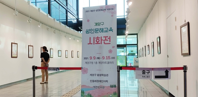 한 주민이 계양아트갤러리에서 열리고 있는 성인문해교육 시화전 작품을 둘러보고 있다. ( 사진 = 계양구 제공 )