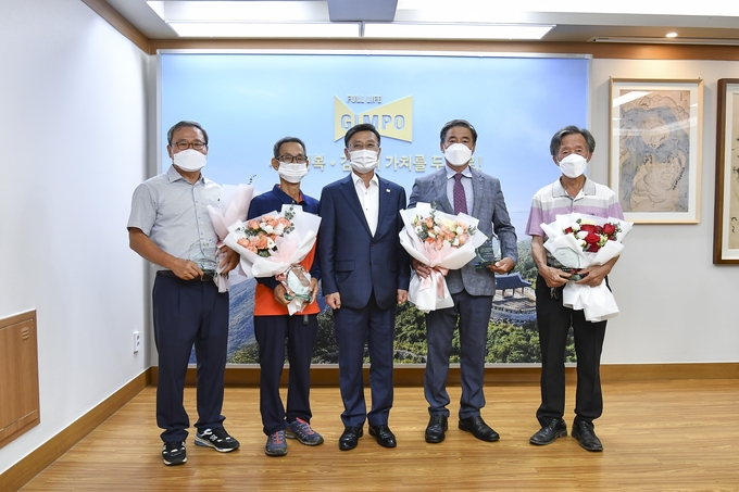 품평회에서 통진읍 동을산리 유영철 친환경재배 농가가 작년 금상에 이어 영예의 대상을 받아 정하영 시장과 기념 사진을 찍고 있다.(사진=김포시청제공)