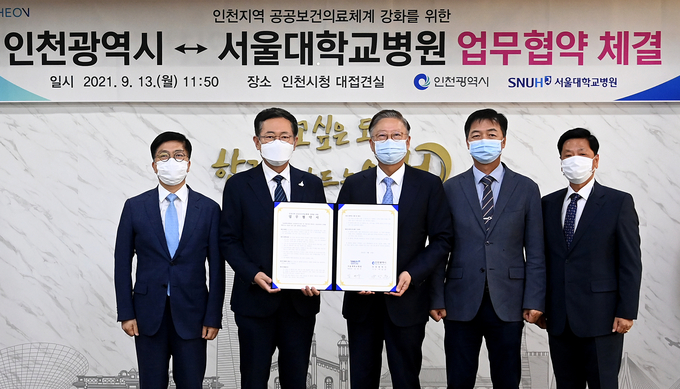 박남춘 인천시장과 김연수 서울대학교병원장이 13일 시청 접견실에서 열린 '인천시-서울대학교병원 업무협약 체결식'에서 협약을 체결한 뒤 기념촬영을 하고 있다. ( 사진 = 인천시 제공 )