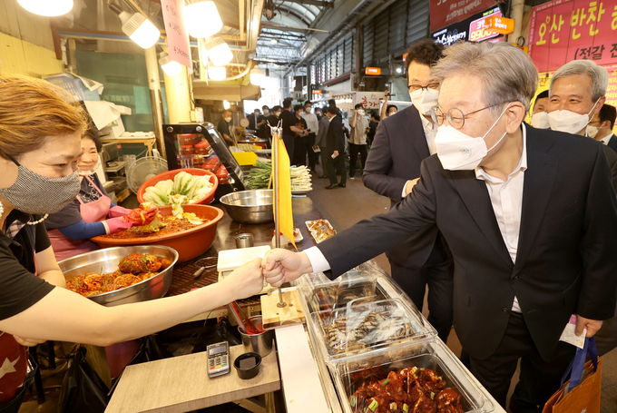 이재명 경기도지사가 오산시 오색시장의 상인과 주먹인사를 나누고 있다 (사진 = 경기사진공동취재단)