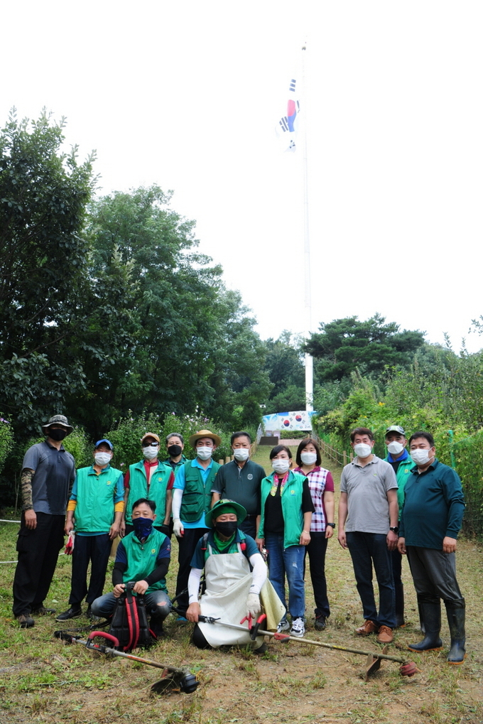 구리시새마을회 지도자와 공무원 20여 명이 아차산 태극기⁃새마을동산에서 환경 정비를 실시했다. (사진=구리시 제공)