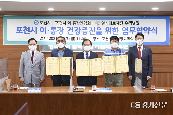 서명한 협약서를 들어보이고 있다. 왼쪽부터 송상국 포천시의회 의장 직무대리 부의장, 채수정 이통장연합회장, 박윤국 포천시장, 장진 우리 병원 이사장, 임종훈 포천시의회 운영위원장 (사진=포천시 제공)