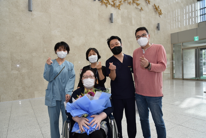 (왼쪽부터 시계방향으로)흉부외과 정윤지 전담간호사, 환자 보호자, 흉부외과 박준석 과장, 환자 보호자, 완치판정 받은 이모씨가 퇴원하기 전 기념촬영을 하고 있다. (사진=성남시의료원 제공)