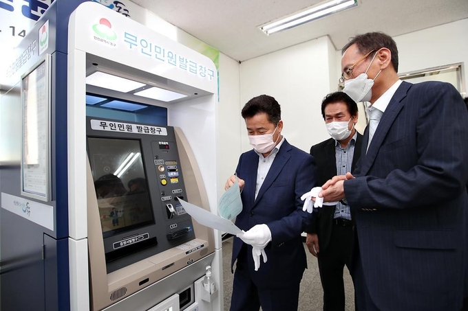 허인환 동구청장이 인천산업용품유통센터 무인민원발급기 설치 제막식에 참석, 민원서류를 살펴보고 있다. ( 사진 = 동구 제공 )