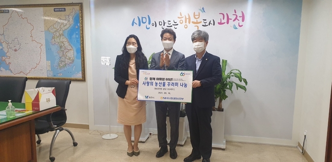 김종천 과천시장(사진 가운데)가 김문호 NH농협 과천시지부장으로부터 사랑의 농산물 꾸러미를 전달받았다. 꾸러미는 추석을 맞아 지역 내 취약계층 가구에 전달될 예정이다. (사진=NH농협 과천시지부 제공)