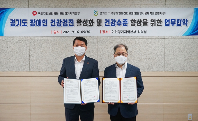 서명철 국민건강보험공단 인천경기지역본부장(사진 왼쪽)과 임재영 경기도지역장애인보건의료센터장(오른쪽)이 16일 오전 건보 경인본부 회의실에서 ‘지역 장애인 건강권 및 의료접근성 향상을 위한 업무협약(MOU)’을 체결하고 기념사진을 촬영하는 모습. (사진=국민건강보험공단 인천경기지역본부)