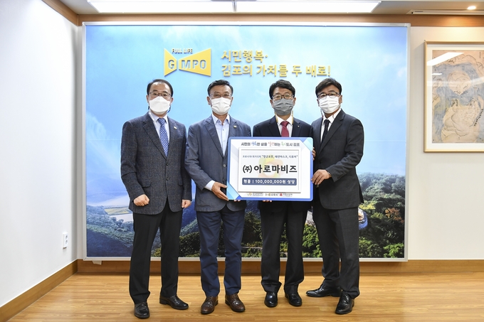 김포시에 1억원상당의 방역물품을 전달한 (주)아로비즈 최천히 회장(오른쪽 두번째)과 정하영 시장 등이 기념사진을 찍고 있다.(사진=김포시제공)
