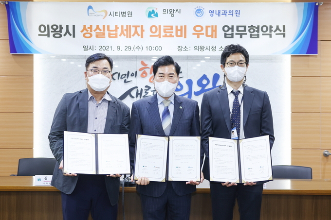 의왕지역 성실납세자들의 의료비 할인 혜택을 위해 시와 지역 의료기관이 손을 맞잡았다. 왼쪽부터 김상돈 시장과 김동준 시티병원장, 윤주환 영내과의원 행정부장이 각자 서명한 협약서를 들어보이고 있다. (사진=의왕시 제공)